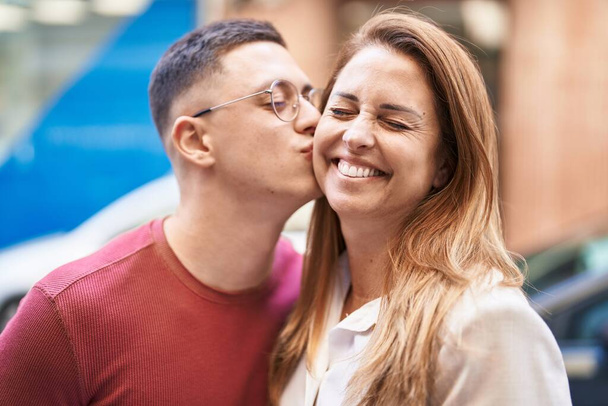 Hombre y mujer madre e hijo abrazándose y besándose en la calle - Foto, Imagen