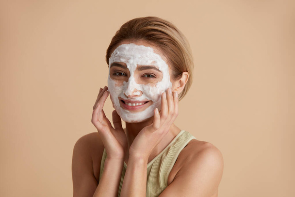 Face Skin Care. Caucasian Woman Cleaning Facial Skin with Foam Soap. Happy Girl Cleansing Face Applying Facial Cleanser Closeup. High Resolution  - 写真・画像