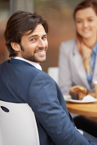 Nad kávou a muffinem vždycky přemýšlíme líp. Portrét šťastného podnikatele sedícího v kavárně se spolupracovníkem - Fotografie, Obrázek