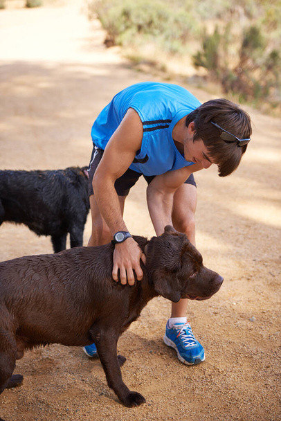 Anche i cani hanno bisogno del loro esercizio. un giovane uomo che si allena all'aperto con i suoi cani - Foto, immagini