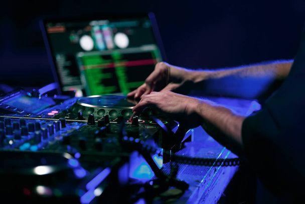Techno dj mixing musical set on party in night club. Disc jockey plays on rap concert in nightclub - Foto, Bild