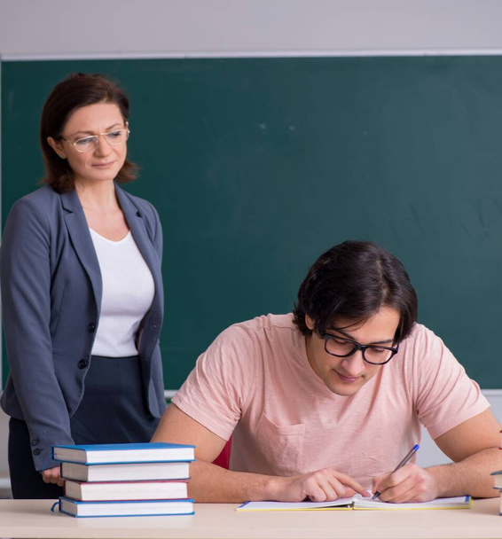 The old female teacher and male student in the classroom - Φωτογραφία, εικόνα