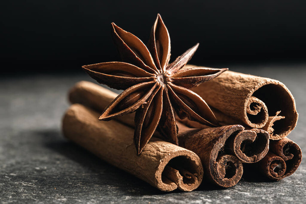 Dry star anise with a bunch of brown cinnamon sticks close up, macro shot. - Photo, Image