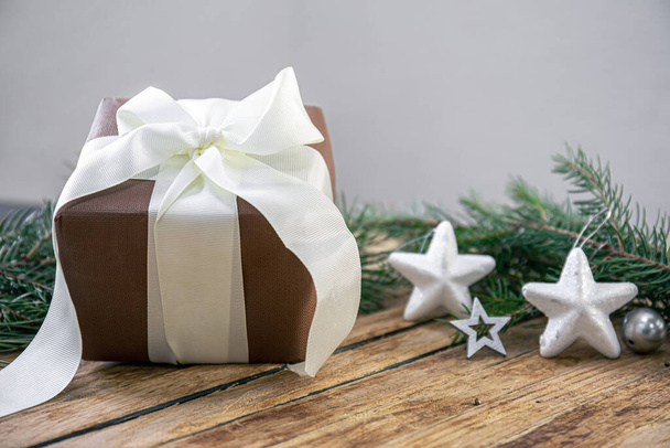 Caja de regalo, detalles decorativos y ramas de abeto sobre un fondo borroso, espacio para copiar. - Foto, Imagen