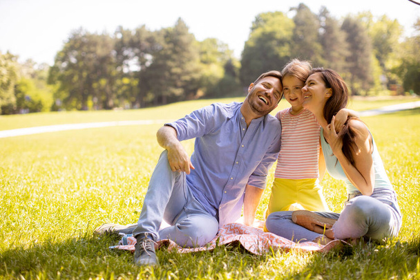 feliz jovem família com bonito pequena filha se divertindo no parque em um dia ensolarado - Foto, Imagem