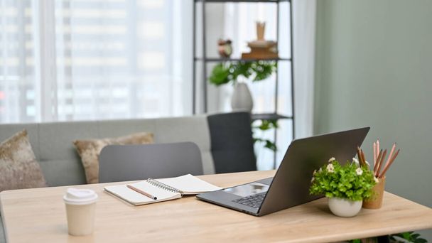 Moderno spazio di lavoro per ufficio urbano con computer portatile, cancelleria, una tazza di caffè e arredamento sul tavolo. - Foto, immagini
