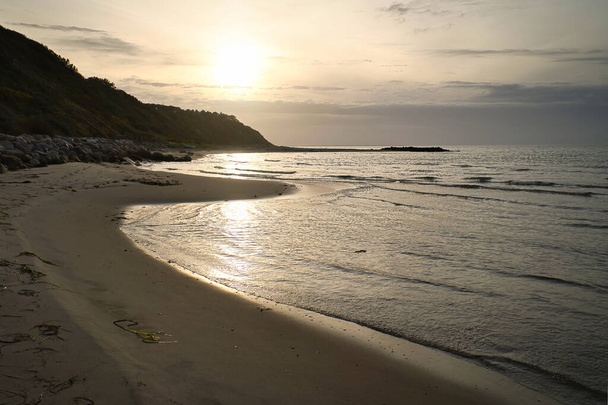 Puesta de sol en la playa de arena en Dinamarca junto al mar. Paisaje costero en la hora de la tarde. Paisaje foto del océano - Foto, imagen
