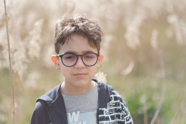 自然界に眼鏡をかけた少年の肖像画です。高品質の写真 - 写真・画像