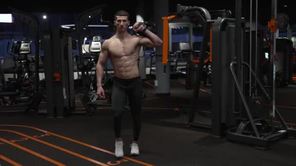 muscular athlete squatting in sport gym with kettlebell. sport athlete squatting with kettlebell in gym. athlete with sport kettlebell equipment in gym - Footage, Video