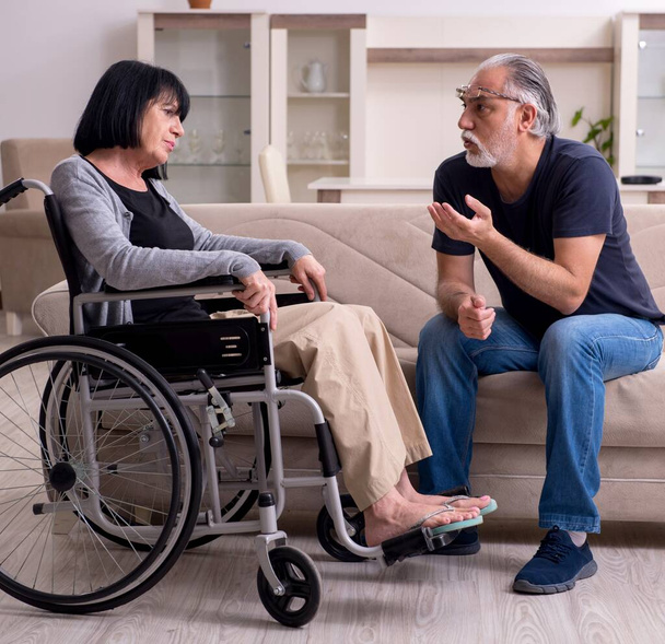 The old husband looking after disabled wife - Photo, Image