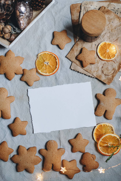 greeting card mockup on the background of gingerbread, holiday sweets, christmas cookies, white sheet of paper mockup - Fotografie, Obrázek