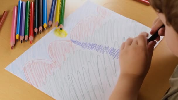 tekening op papier, krabbelende jongen, jongen tekening op papier met kleurrijk potlood - Video