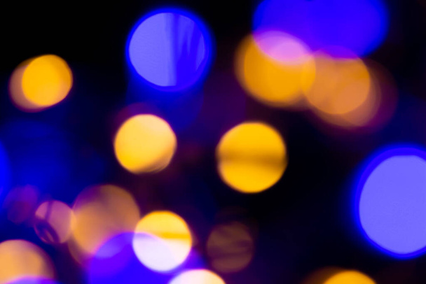 Bokeh background. Christmas lights. Defocused colorful lights in darkness. - Photo, Image