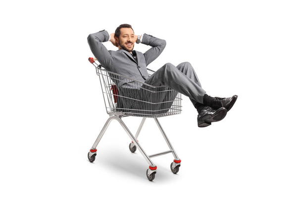 Businessman sitting and resting inside a shopping cart isolated on white background - Valokuva, kuva