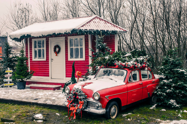 Decorada casa do Papai Noel com um carro vintage vermelho no quintal. Paisagem de Ano Novo foto. - Foto, Imagem