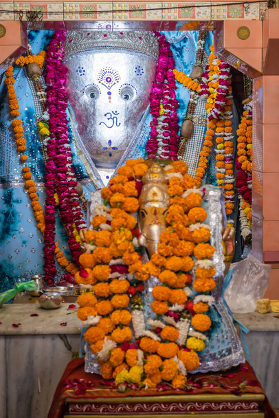 hindu god ganesha idol worshiped with flowers vertical shot from flat angle image is taken at ganesh temple ratanada jodhpur rajasthan india. - Photo, Image