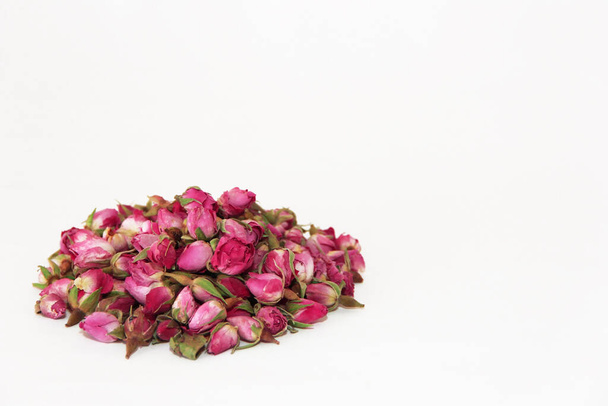 pequeños brotes secos de rosa natural para preparar té fragante, aislar sobre un fondo blanco - Foto, imagen