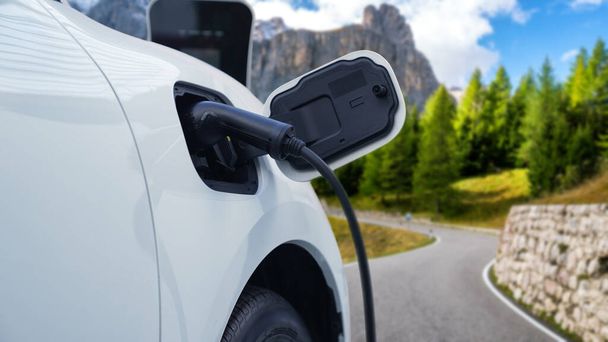 電気自動車の先進的な走行コンセプトは、目的地に到達する前にリモートエリアの充電ステーションからエネルギーを充電するのを停止し、 EV車は緑の環境のための再生可能エネルギーとクリーンエネルギーを搭載 - 写真・画像