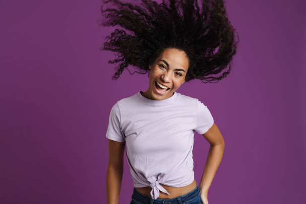 Young black woman with wavy hair making fun at camera isolated over purple background - Fotó, kép