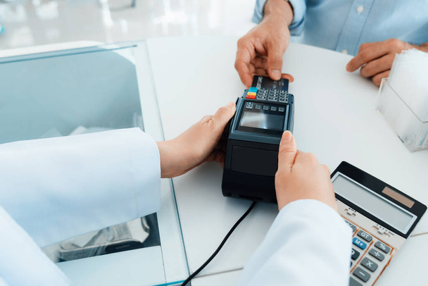 Payment by credit card with payment terminal in qualified drugstore or hospital. Modern payment of electric money. Closeup customer purchase medication in pharmacy with credit card on pos. - Foto, afbeelding