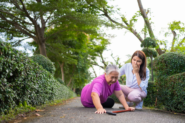 Asian senior woman fell down on lying floor because faint and limb weakness and Crying in pain form accident and her daughter came to help support. Concept of old elderly insurance and health care - Valokuva, kuva
