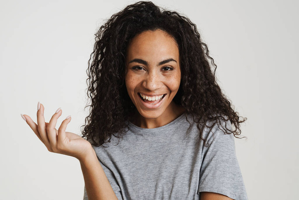 Young black woman with wavy hair laughing and holding copyspace isolated over white background - Φωτογραφία, εικόνα