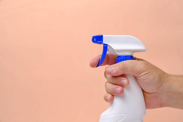 Sprayer for cleaning and washing windows, plumbing in hand beige background - 写真・画像
