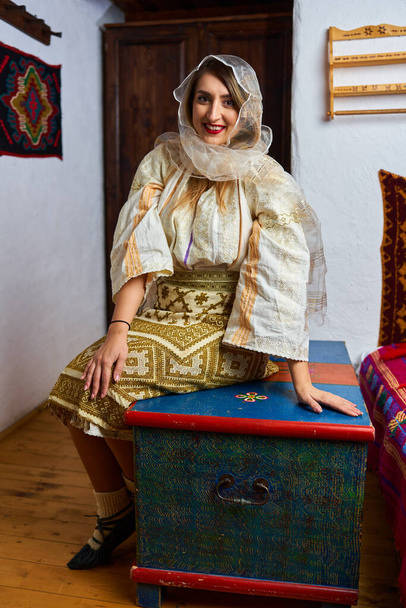 Young Romanian woman in traditional bride popular costume in a vintage home - Photo, Image