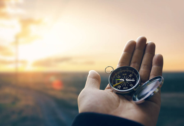 Путешественник исследователь человек держа компас в руке в горах на восходе солнца, точка зрения. - Фото, изображение