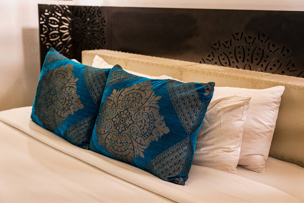 Cuscino a righe con lenzuolo su testiera in letto d'albergo - Foto, immagini