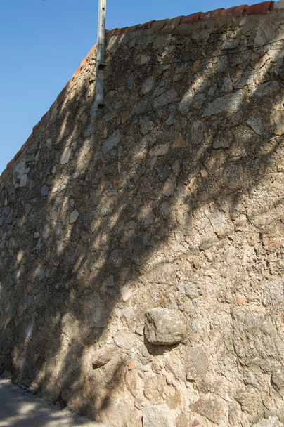 Kamenná zeď venkovského domu se stínem vrhaným stromem - Fotografie, Obrázek