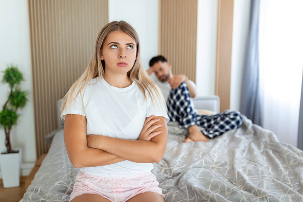Frustrated sad girlfriend sit on bed think of relationship problems, thoughtful couple after quarrel lost in thoughts, upset lovers consider break up, offended person disappointed by boyfriend - Photo, Image