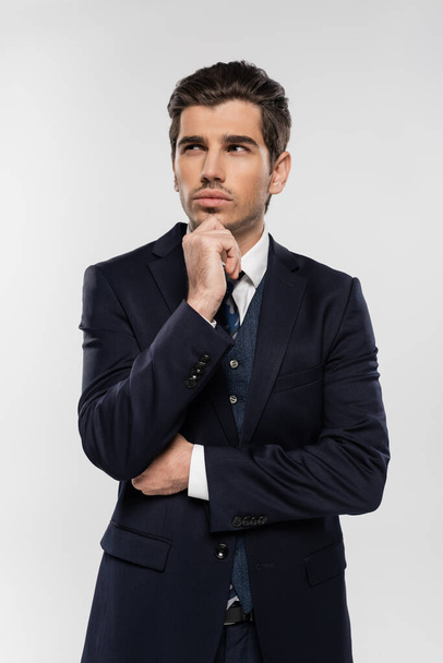 pensive businessman in suit standing and looking away isolated on grey - Foto, Imagem