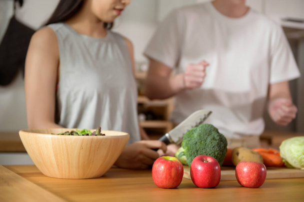 An Asian young couple enjoy cooking with healthy vegetables and fruits ingredients in kitchen at home , healthy wellness lifestyle concept. - Foto, afbeelding