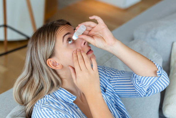 Woman using eye drop, woman dropping eye lubricant to treat dry eye or allergy, sick woman treating eyeball irritation or inflammation woman suffering from irritated eye, optical symptoms - Foto, Imagen