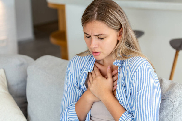 Young woman having chestpain,Acute pain, possible heart attack.Effect of stress and unhealthy lifestyle concept. - Foto, immagini