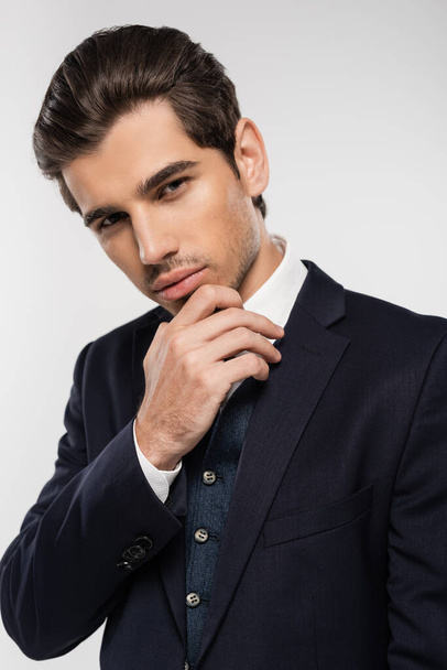 good looking and young businessman in formal wear looking at camera isolated on grey - Photo, Image