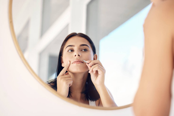 Beauty, mirror and tweezers with a woman in the bathroom of her home for hair removal or skincare. Facial, wellness and cleaning with an attractive young female face in her house in the morning. - Fotoğraf, Görsel