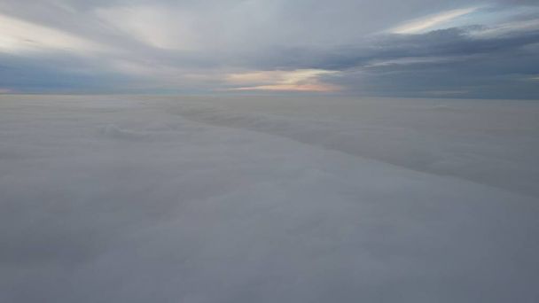 Um oceano celestial de nuvens. Voando em um drone. Os raios amarelos claros do sol no por do sol são refletidos na superfície das nuvens. Dupla camada de nuvens e nevoeiro pesado. Boa noite. Cazaquistão - Foto, Imagem