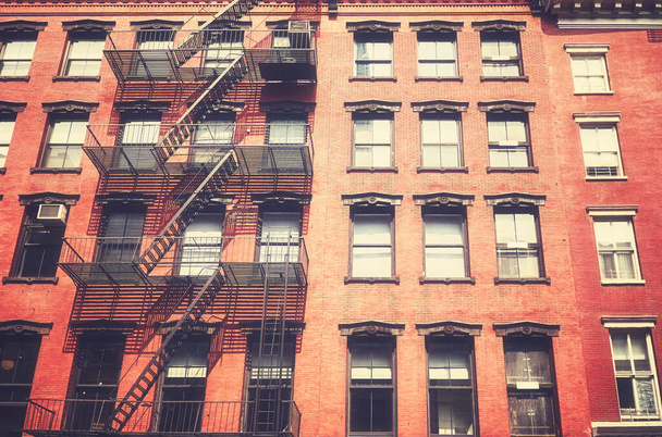 Old townhouse building with iron fire escape, color toning applied, New York City, USA. - Fotó, kép