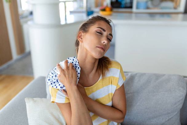 Pain in the shoulder. Upper arm pain, People with body-muscles problem, Healthcare And Medicine concept. Attractive woman sitting on the bed and holding painful shoulder with another hand. - Foto, Bild
