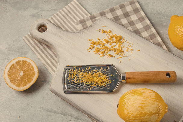 Grated lemon zest, on a cutting board, with a grater , top view, no people, - Fotoğraf, Görsel