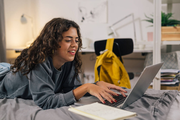 Young woman types on her laptop - Φωτογραφία, εικόνα