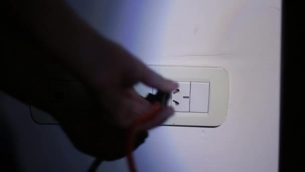 Mužská ruka pomocí baterky Při připojení zásuvky na zdi v bytě ve tmě během výpadku proudu nebo výpadku napájení. Zavři. Rozlišení 4K. - Záběry, video