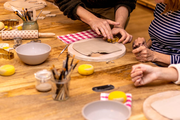 Christmas pottery workshop. Teacher teaching how to work to his students. - 写真・画像