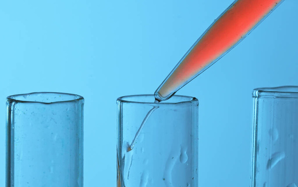 Drop from pipette drips into laboratory test tubes. - Photo, Image