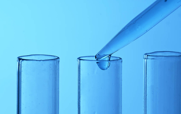 Drop from pipette drips into laboratory test tubes. - Foto, imagen