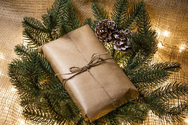 christmas gift in kraft paper next to the tree - Zdjęcie, obraz