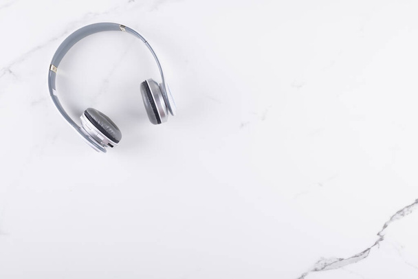 Vista superior de auriculares blancos sobre fondo de mármol blanco con espacio de copia, concepto de escucha plana lay - Foto, Imagen