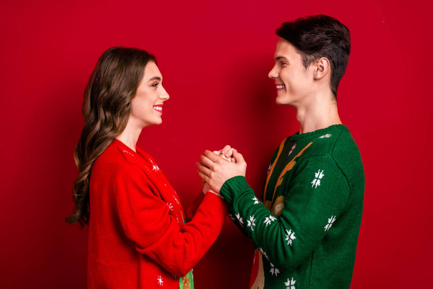 Profile photo of two idyllic peaceful lovers hold arms look each other eyes isolated on red color background. - Photo, Image